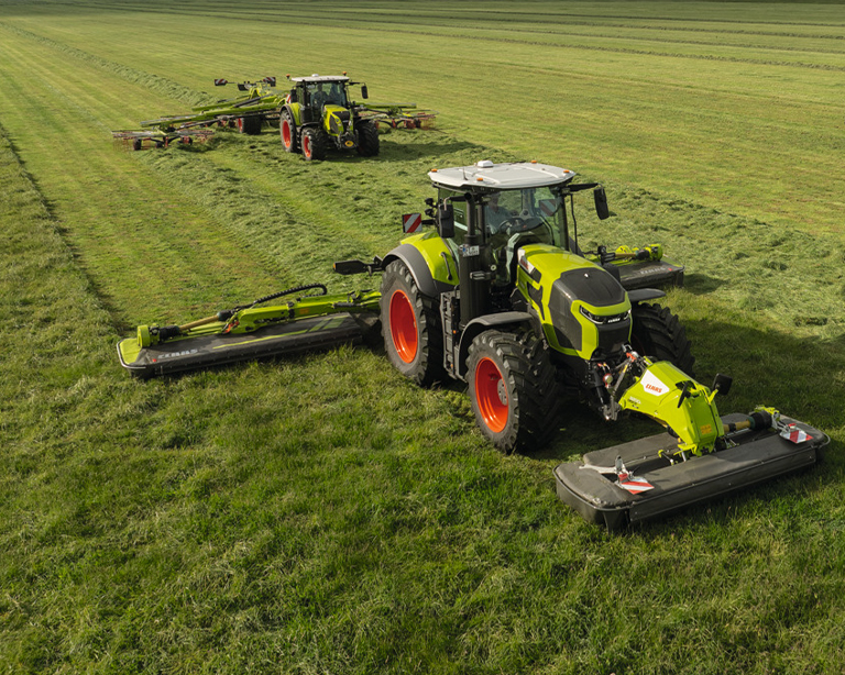 Ciągniki CLAAS z kosiarkami i zgrabiarką podczas zbioru zielonki – maszyny First CLAAS